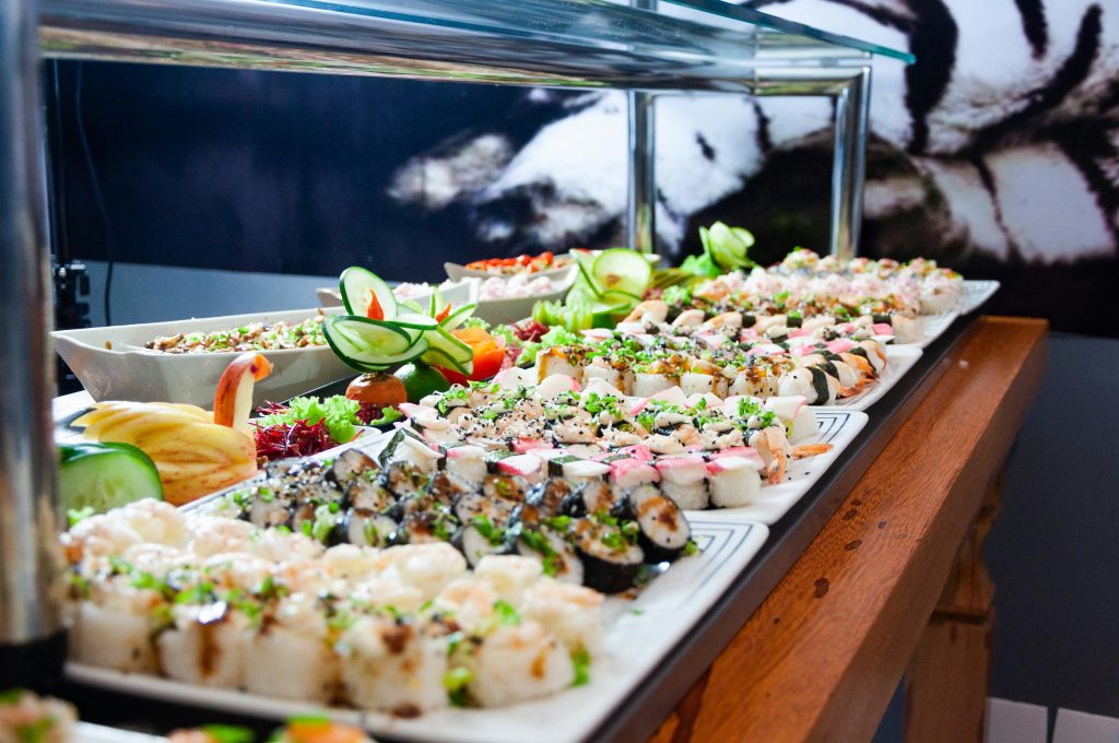 pexels photo 2264036 2264036 A colorful and diverse sushi buffet featuring an array of fresh rolls, garnished with vegetables.