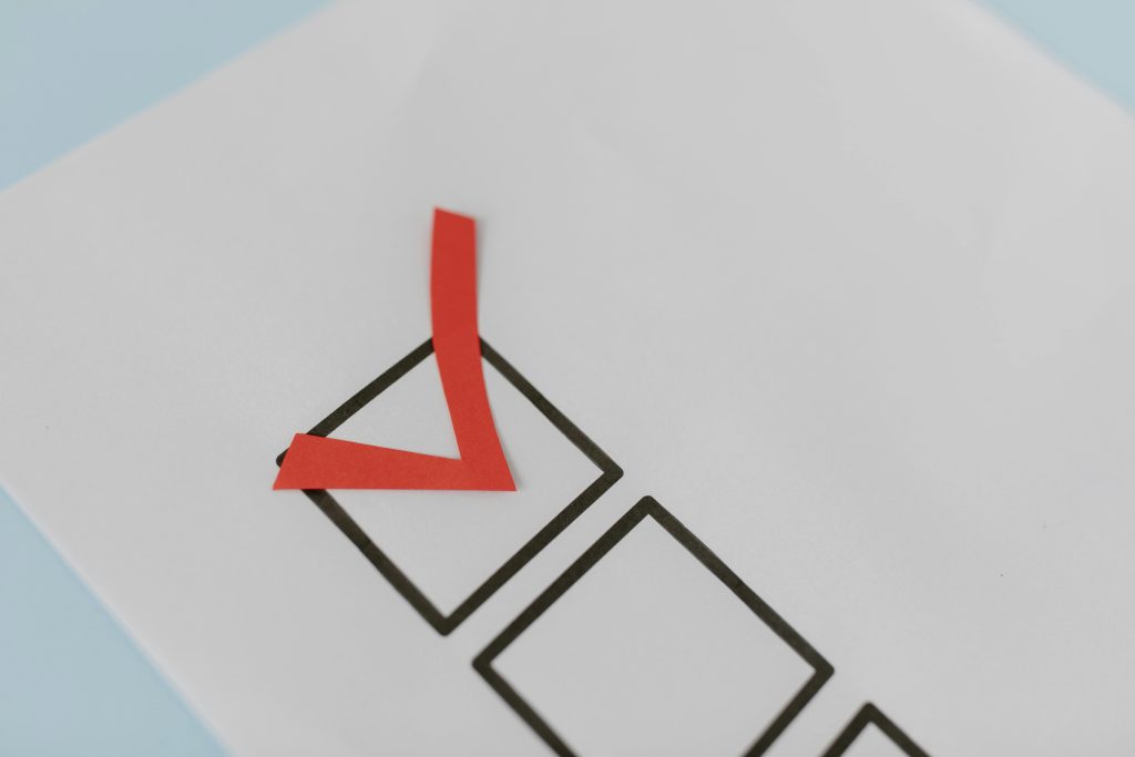pexels photo 8850721 8850721 Close-up of a red check mark on a crisp white paper with black boxes, symbolizing completion.